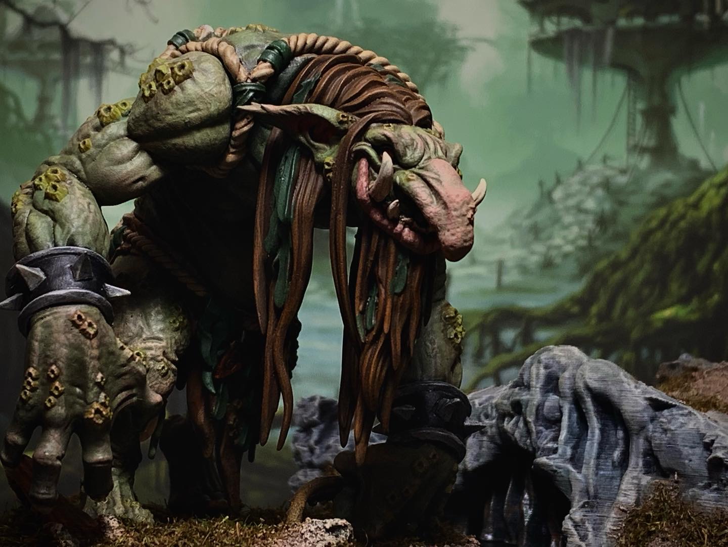 Miniatura de troll de pântano em tons verdes, com dreadlocks e bracelete espinhado